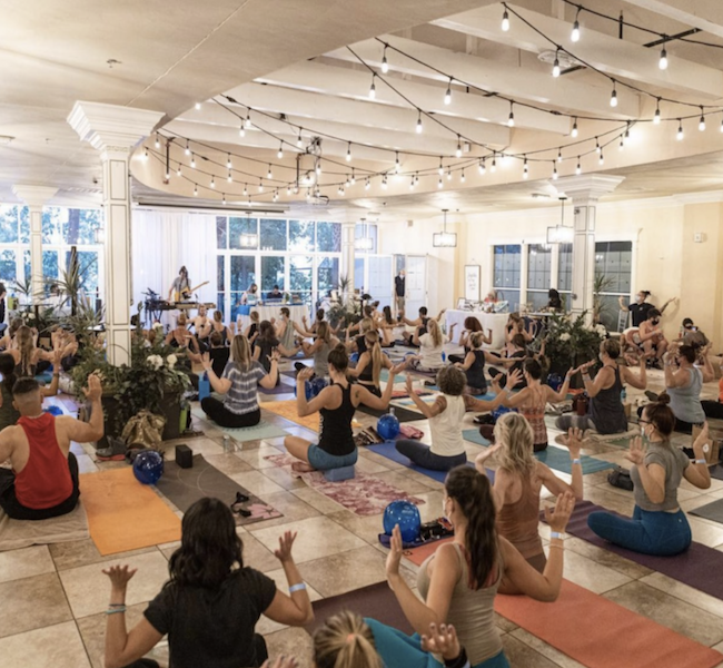 Venue that shows people doing yoga next to the lake